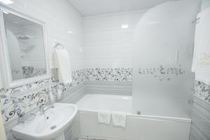a white bathroom with a tub and a sink at Gur Emir Palace boutique hotel in Samarkand +55 photos