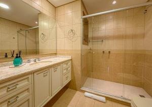 ein Badezimmer mit Dusche und Waschbecken in der Unterkunft VV Suítes - Apto Rua Coberta in Gramado + 24 Fotos