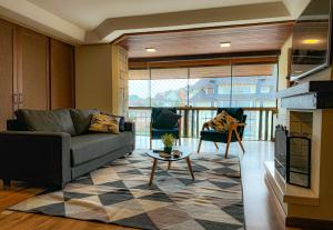 ein Wohnzimmer mit Sofa und Tisch in der Unterkunft VV Suítes - Apto Rua Coberta in Gramado