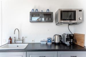 ザントフォールトにあるVilla 't Spokeduinのシンクと電子レンジ付きのキッチン