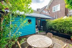 a blue house with a table and chairs at Ocho in Zandvoort