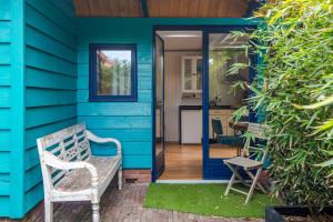 a blue house with a bench on the porch at Ocho in Zandvoort +29 photos