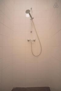 een douche met een douchekop in een badkamer bij Stop & Stay 2 in Zandvoort