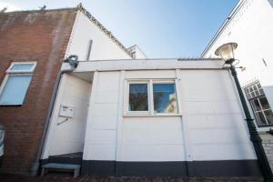 een hond die uit het raam van een garage kijkt bij Stop & Stay 2 in Zandvoort