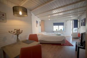een slaapkamer met een bed, een tafel en stoelen bij Stop & Stay 2 in Zandvoort