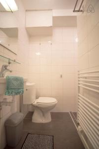 een witte badkamer met een toilet en een wastafel bij Stop & Stay 2 in Zandvoort +29 foto's