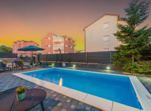 a swimming pool in front of a building at Villa S in Vodice