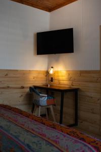 a room with a table and a television on a wall at Patagonia Mai Casa Boutique in Puerto Natales