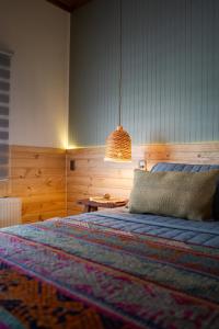 a bedroom with a bed and a pendant light at Patagonia Mai Casa Boutique in Puerto Natales