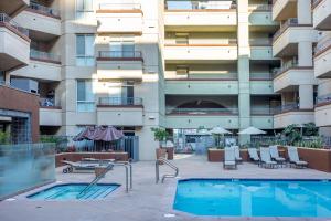 une piscine devant un bâtiment dans l'établissement San Diego's Diamond: Snowbird-friendly studio near ocean with pool, hot tub, gym, balcony - dogs OK, à San Diego