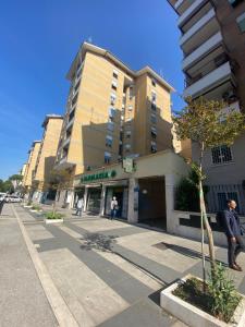 Un uomo in piedi su un marciapiede di fronte a un edificio di Ophele House Rome a Roma