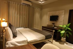 a bedroom with a bed with a desk and a television at Jaipur Qila - A Boutique Hotel and Rooftop Cafe in Jaipur