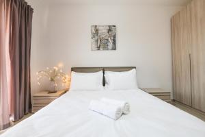 a bedroom with a white bed with two towels on it at Spacious 2 bedroom apartment in Cospicua