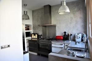 a kitchen with a stove and a sink at Family Home Marie in Zandvoort