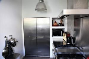 a kitchen with a stainless steel refrigerator and a stove at Family Home Marie in Zandvoort