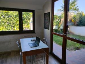 a laptop sitting on a table in a room with windows at Lillo Home in Isernia