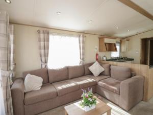 a living room with a brown couch and a kitchen at Hazel in Denny +13 photos