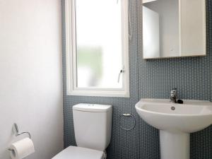 a bathroom with a white toilet and a sink at Hazel in Denny