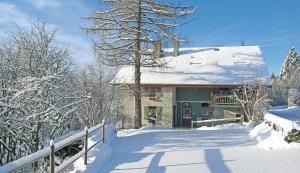 a house with a snow covered roof with a fence at L'Ourserie B&B in Saint-Paul-en-Chablais +1 photo