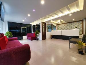 a living room with a red couch and chairs at G3 Star Comfort in Chennai