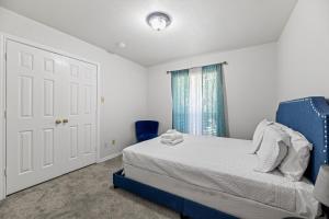 a bedroom with a blue bed and a window at Spacious Single-Story Plano Home in Plano