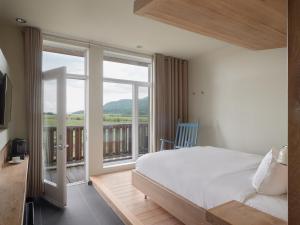 a bedroom with a large bed and a balcony at Hôtel & Spa Le Germain Charlevoix in Baie-Saint-Paul +93 photos