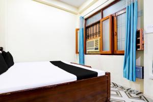 a bedroom with a bed and a window at Hotel O Suryawanshi in Lucknow