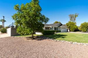 a house with a tree in the front yard at Heated pool, Sports Court, Pool table, King beds in Tempe Junction
