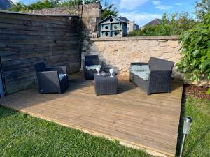 a patio with chairs and a table and a fence at Maison cosy avec jacuzzi privatif proche Reims in Braine