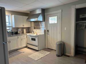 a kitchen with white cabinets and a stove top oven at Apt A The Yellow Shuttered House in Sharon