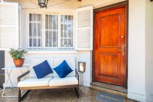 a couch with blue pillows sitting in front of a door at APUMANQUE HOUSE in Santiago