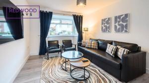 a living room with a black leather couch and chairs at Spacious 3-Bedroom Serviced House, Free On-Street Parking, Free WiFi By Redwood Stays in Aldershot