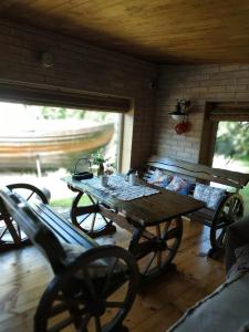 a wooden table in a room with a bench at 100SaulesVikingi in Grobiņa +34 photos