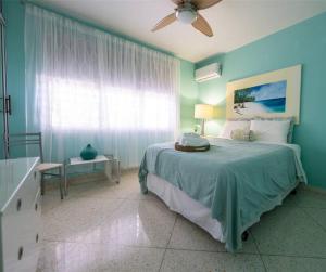 a blue bedroom with a bed and a window at Hacienda Cumbre Bella in Ciales
