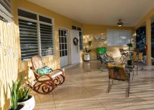 a porch with chairs and a table in a house at Hacienda Cumbre Bella in Ciales