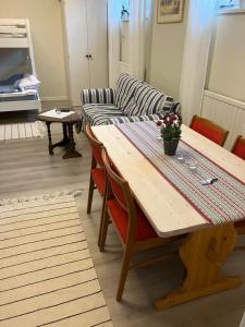 a living room with a wooden table and a couch at Gästboende Mjölnaren in Vadstena