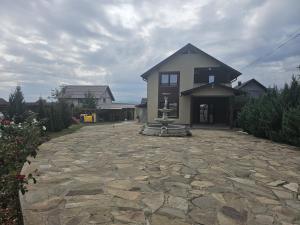 a house with a stone driveway in front of a house at Vila Medana- Neamt in Humuleşti