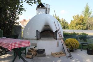 a outdoor pizza oven with a table and a tablecloth at Motelnet.T in Mosonmagyaróvár