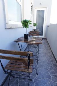 three benches and a table with potted plants on it at AL Barbinha in Faro