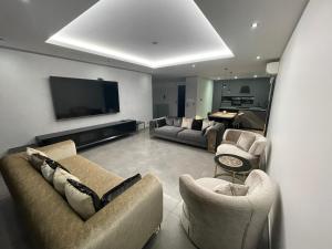 a living room with couches and a flat screen tv at Maison Jacuzzi in Thonon-les-Bains