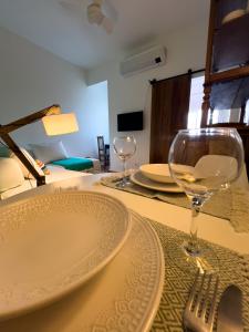a table with a plate and two glasses on it at Apartamento praia! Aconchegante e central! in Rio de Janeiro