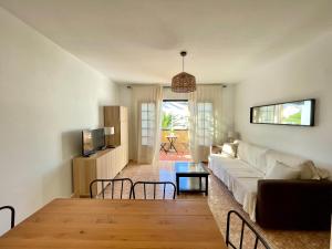 een woonkamer met een bank en een tafel bij Encanto del mar, shared pool in Puerto del Carmen