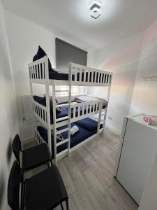 a bedroom with two bunk beds and a chair at Willesden Green Budget Guesthouse in London