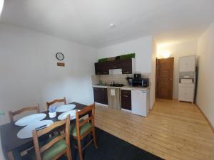 a kitchen and dining room with a table and chairs at Dráva Fishing Apartman in Drávakeresztúr