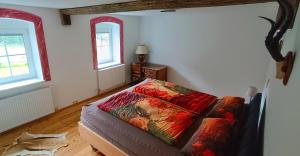 a bedroom with a bed and two windows at Erlebnishof Steinkellnergut in Henndorf