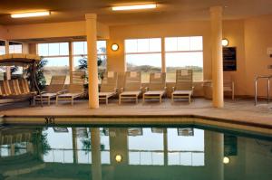 a pool in a hotel with chairs and a table at Oceanfront Lodge in Crescent City