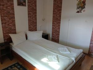 a bed with white sheets and two pillows on it at Casa Hermina in Sovata