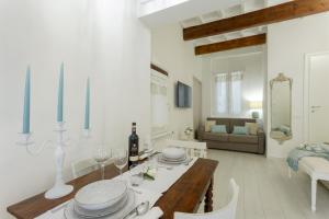 a white living room with a table and a couch at Elegante Appartamento a 2 passi dal Duomo in Florence +17 photos