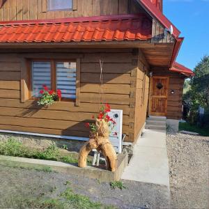 eine Holzhütte mit einer Veranda mit Blumen darin in der Unterkunft Chalupa nad sadom in Liptovská Kokava