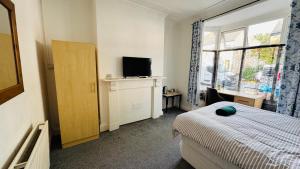 Un dormitorio con una cama y un televisor y una ventana. en Ella street Double room, en Hull 14 fotos más